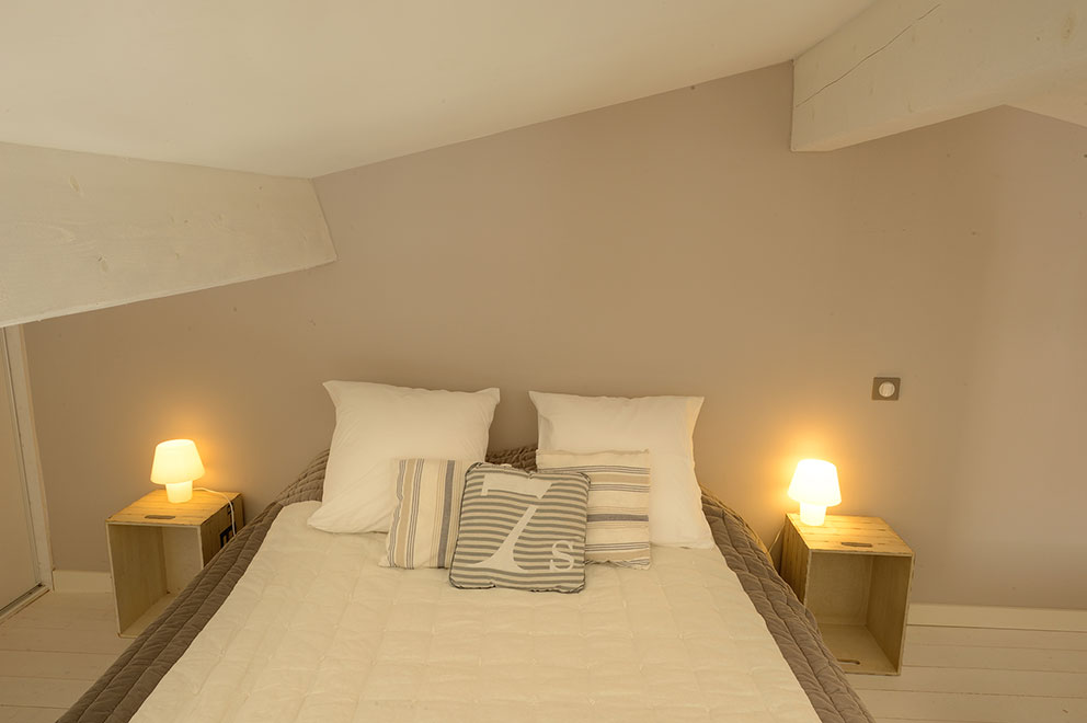 Queen size bed on the mezzanine in the guest house la plage in Sète